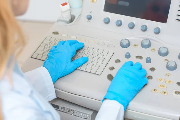 Cropped shot of female obstetrician gynecologist in gloves working with ultrasonic scanner — Stock Photo