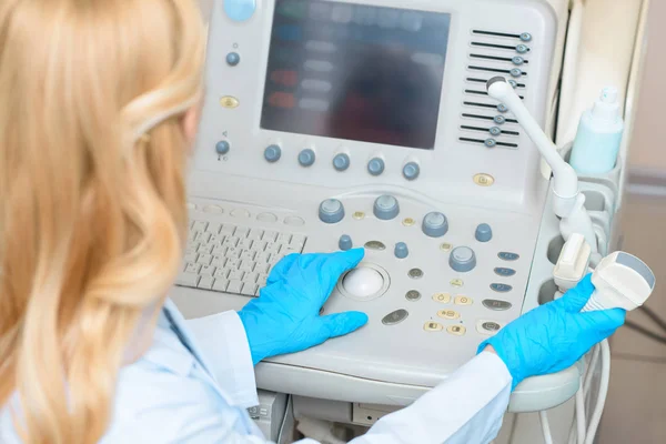 Ginecologista obstetra em luvas que trabalham com scanner ultrassônico — Fotografia de Stock