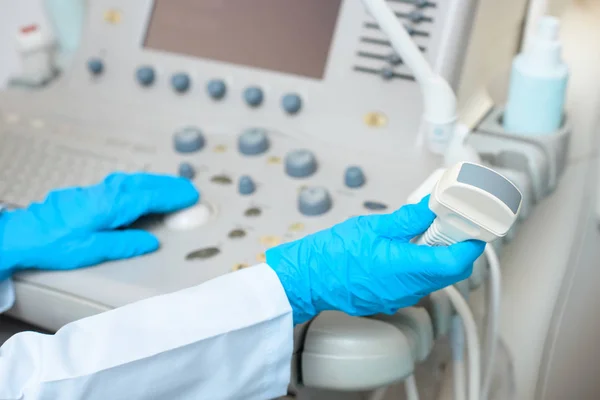 Cropped shot of obstetrician gynecologist in gloves working with ultrasonic scanner — Stock Photo