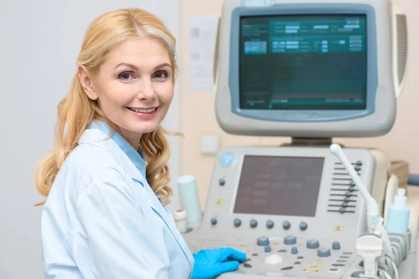 Obstetrician gynecologist sitting at ultrasonic scanner and looking at camera — Stock Photo
