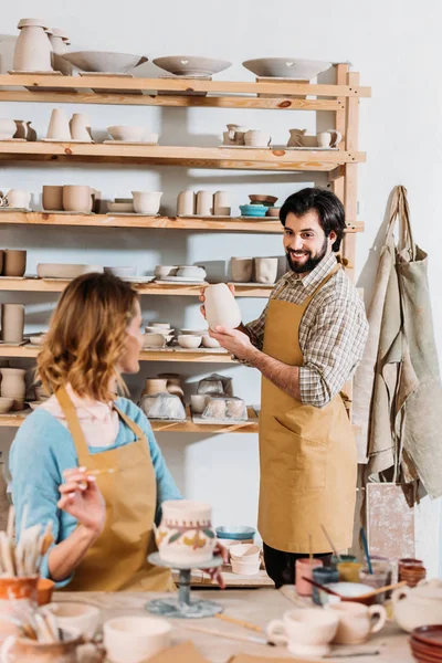 Two potters working with ceramic dishware in workshop — Stock Photo