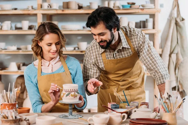 Potters painting traditional ceramic jug in workshop — Stock Photo