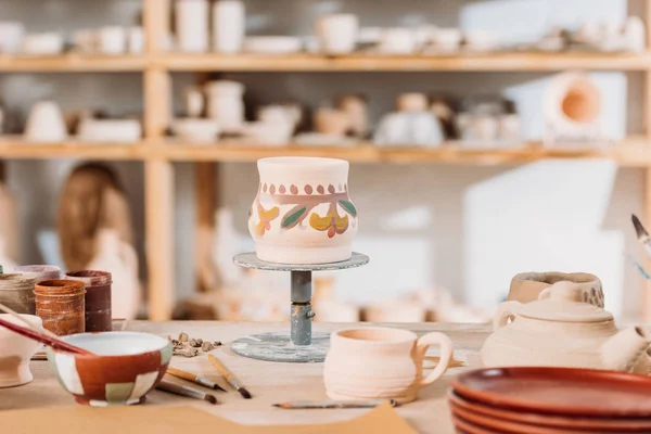 Traditionelle bemalte Keramikkanne auf dem Tisch in der Töpferei — Stockfoto