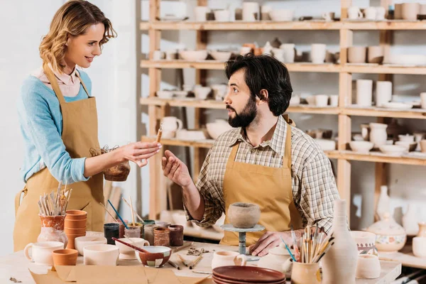 Glückliche Töpfer stellen Keramikgeschirr in Werkstatt her — Stockfoto