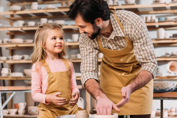 Adorable child with teacher using pottery wheel in workshop — Stock Photo