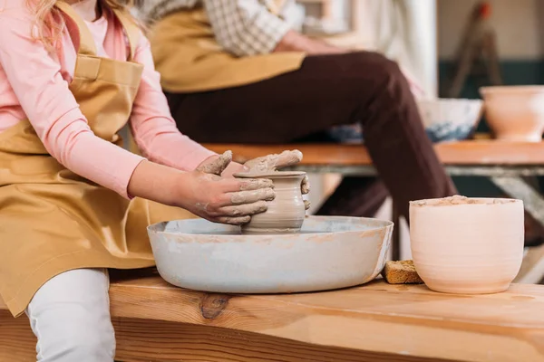 Cropped view of kid making ceramic pot in workshop with teacher — Stock Photo