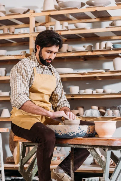 Töpfer stellt Keramiktopf auf Töpferscheibe in Werkstatt her — Stockfoto