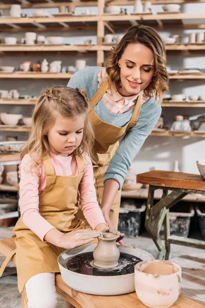 Teacher and kid making ceramic pot in pottery workshop — Stock Photo