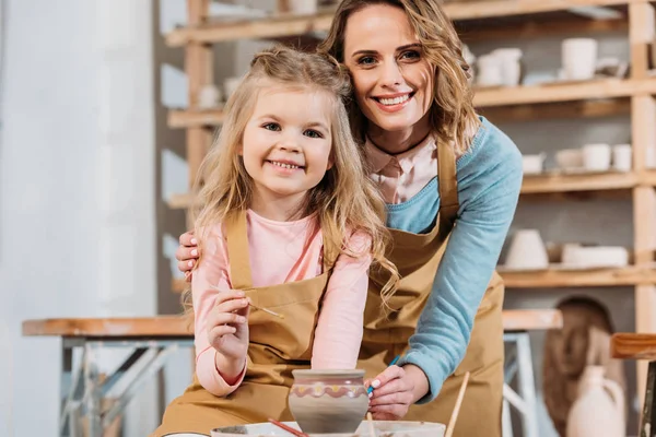 Professeur souriant et enfant peinture pot en céramique ensemble dans l'atelier de poterie — Photo de stock