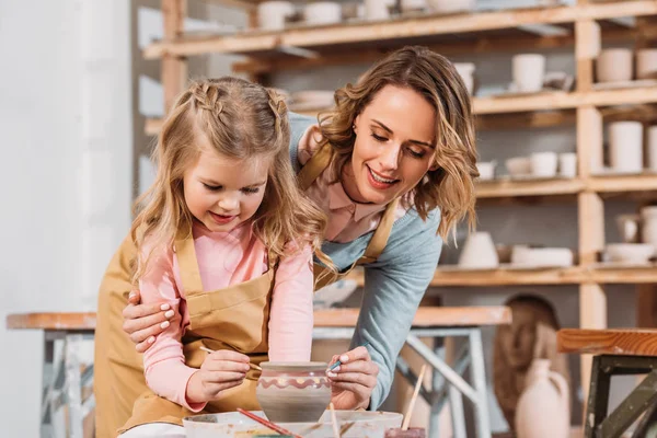 Professeur et enfant peinture pot en céramique dans l'atelier de poterie — Photo de stock