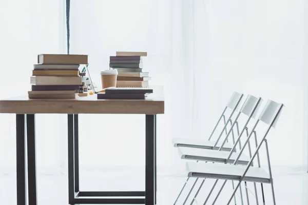 Интерьер комнаты со стульями и столом с книгами — стоковое фото