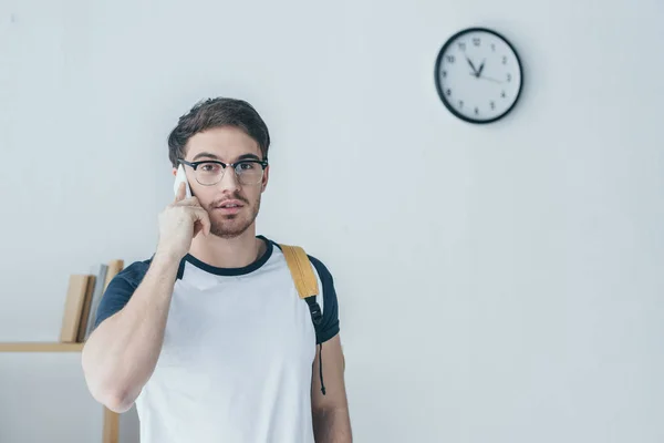 Estudante bonito do sexo masculino falando no smartphone — Fotografia de Stock