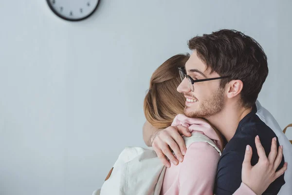 Felice uomo abbracciare ragazza con zaino — Foto stock