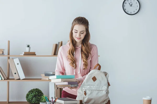 Atractiva estudiante femenina con libros y mochila - foto de stock