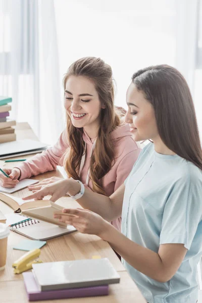 Multiethnic girls studying together and reading in books — Stock Photo