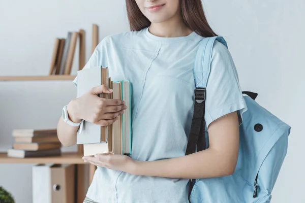 Vue recadrée de fille avec sac à dos tenant des livres — Photo de stock