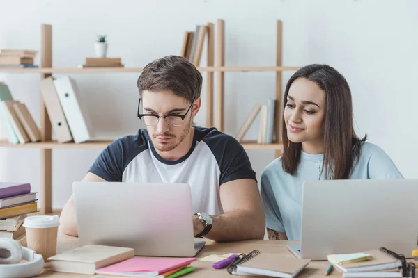 Coppia di studenti multietnici che studiano con computer portatili — Foto stock