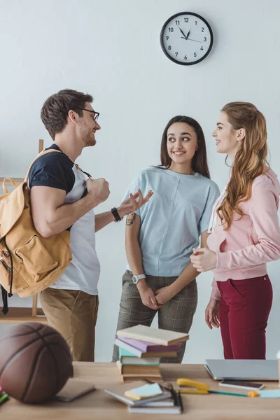 Young happy students standing and talking together — Stock Photo