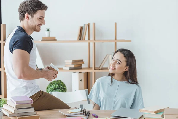 Pareja de sonrientes estudiantes multiétnicos que estudian juntos - foto de stock