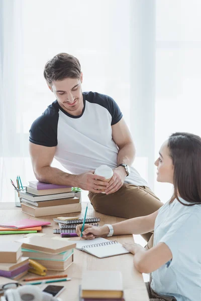 Coppia di studenti multietnici che studiano a tavola con libri e quaderni — Foto stock