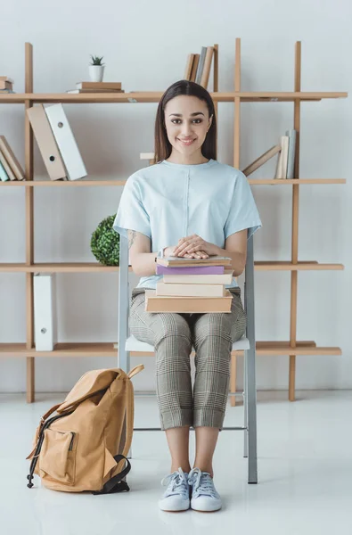 Brünette Studentin sitzt mit Büchern und Rucksack — Stockfoto