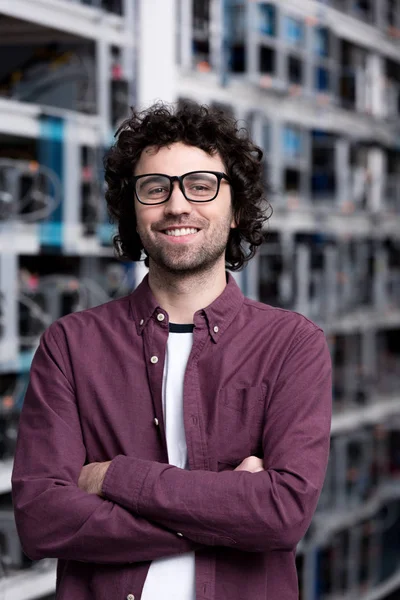 Young computer engineer with crossed arms at cryptocurrency mining farm — Stock Photo