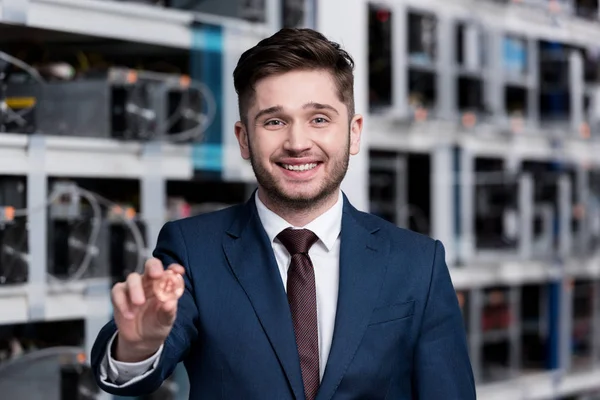 Successful young businessman holding bitcoin at cryptocurrency mining farm — Stock Photo