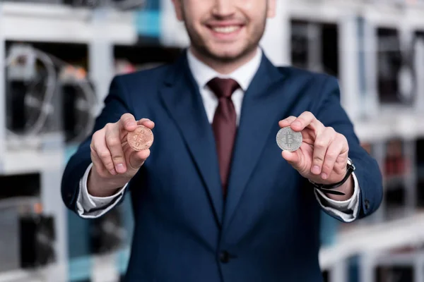 Tiro recortado de empresário sorridente segurando bitcoins na fazenda de mineração criptomoeda — Fotografia de Stock