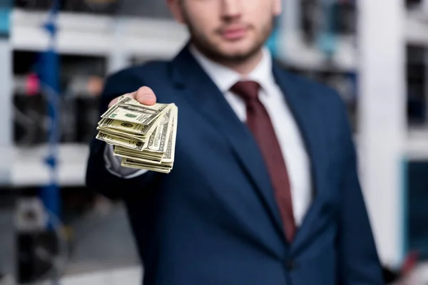 Cropped shot of young businessman holding stack of cash at ethereum mining farm — Stock Photo