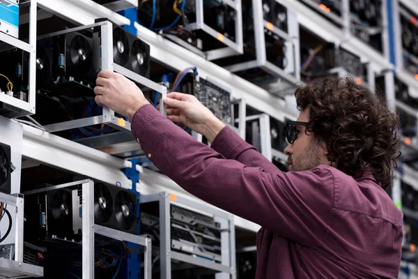 Computer engineer taking out box with graphic card at ethereum mining farm — Stock Photo