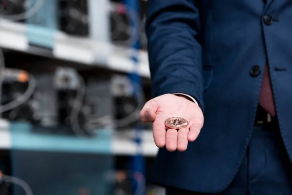 Cropped shot of businessman holding bitcoin at cryptocurrency mining farm — Stock Photo