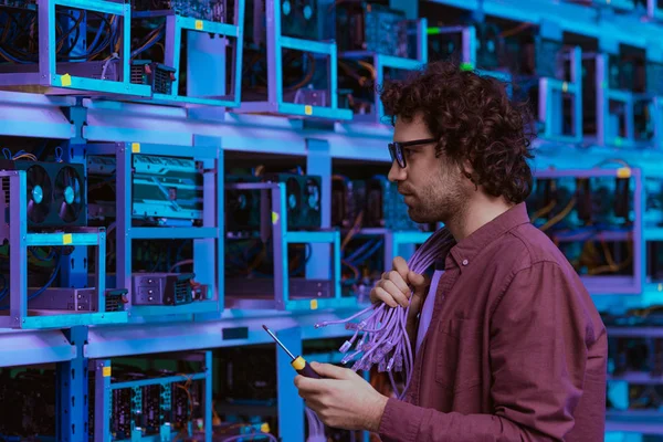 Computer engineer with wires on shoulder at ethereum mining farm — Stock Photo