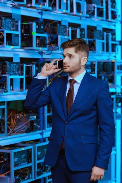 Beau jeune homme d'affaires parlant par téléphone à la ferme minière éthérique — Stock Photo