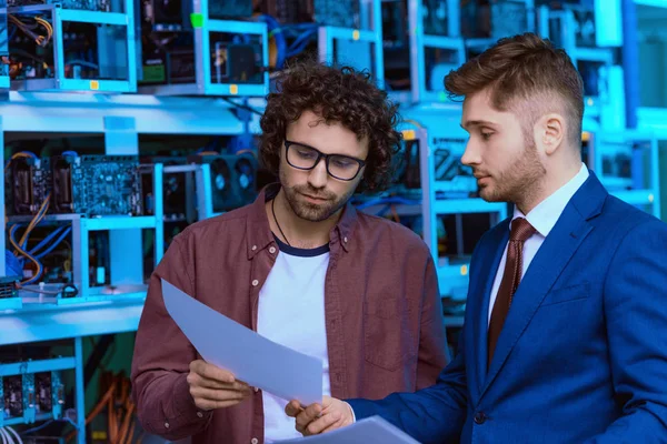 Young businessman and computer engineer working together at ethereum mining farm — Stock Photo