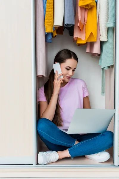 Attrayant jeune femme assise à l'intérieur de l'armoire et de travailler avec ordinateur portable à la maison — Photo de stock