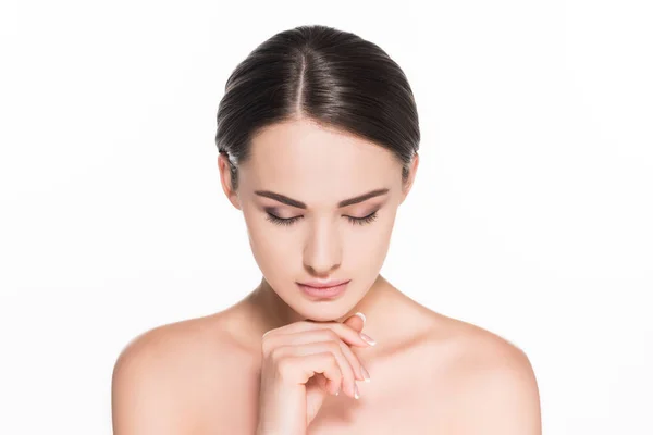 Bella giovane donna guardando giù e toccando il mento isolato su bianco — Foto stock