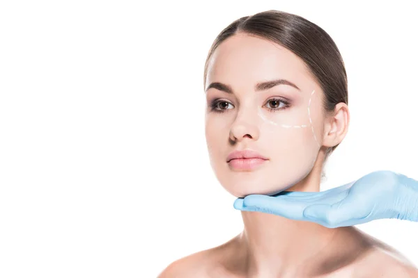 Лікар торкається обличчя красивої жінки з пунктирною лінією для пластичної хірургії ізольовано на білому — стокове фото
