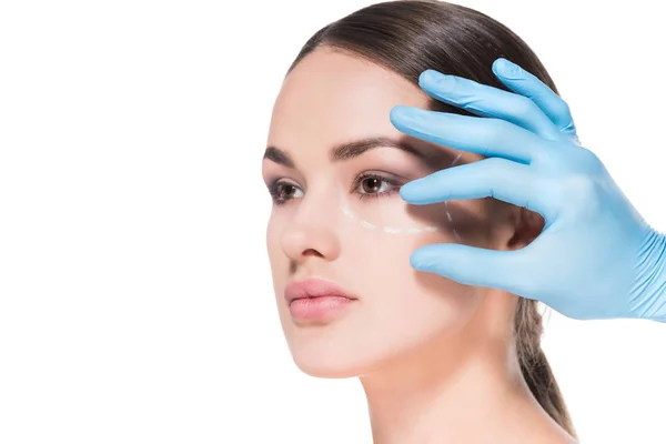 Médecin toucher le visage de la jeune femme avec ligne pointillée pour la chirurgie plastique isolé sur blanc — Photo de stock