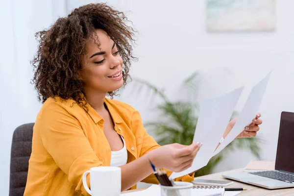 Young mixed race woman doing paperwork at office — Stock Photo