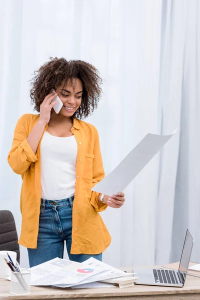 Femme attrayante avec des papiers d'affaires parlant par téléphone — Photo de stock