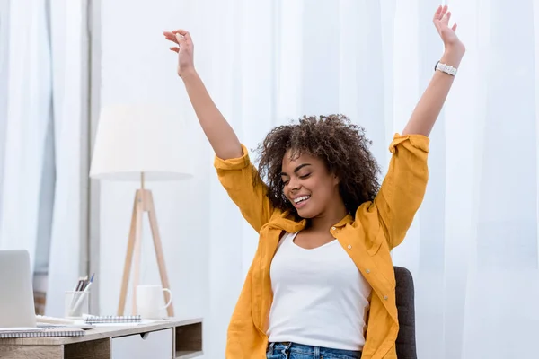 Happy young woman with raised hands — Stock Photo
