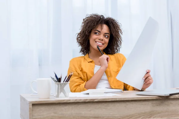 Glücklich nachdenkliche junge Frau beim Papierkram — Stockfoto