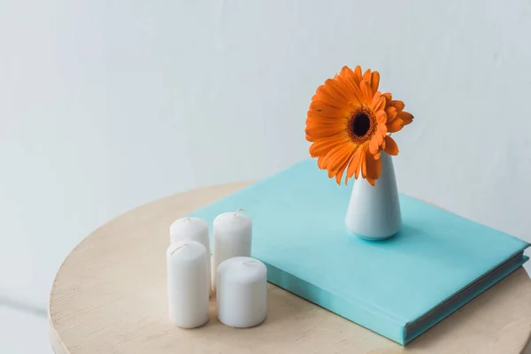 Квітка Гербера і свічки на дерев'яному столі — стокове фото