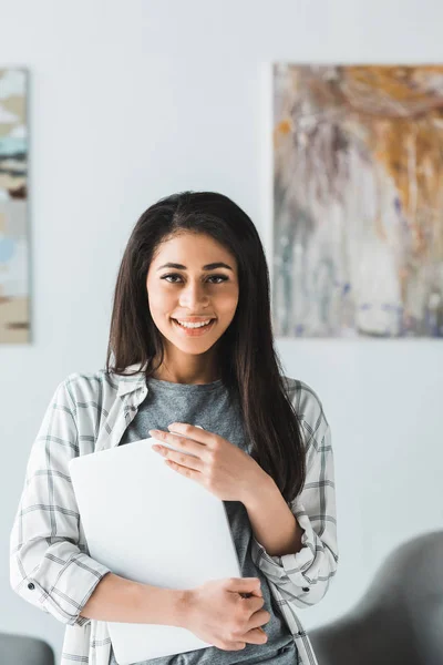 Smiling young woman holding blank paper — Stock Photo