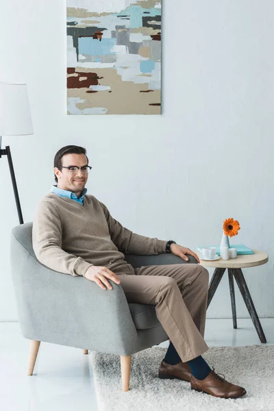 Homem vestindo roupas casuais sentado na cadeira — Fotografia de Stock