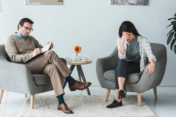 Upset african american woman in office with male psychologist — Stock Photo