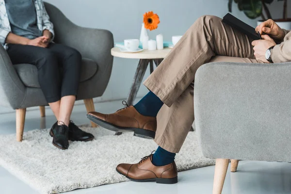 Cropped view of woman visiting psychotherapist in cozy doctor office — Stock Photo