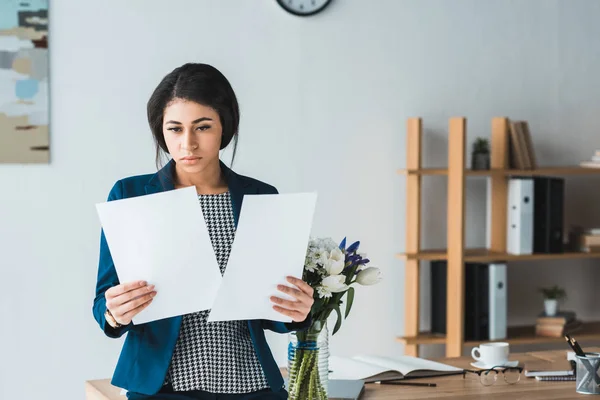 Donna d'affari in cerca di documenti contrattuali in ufficio moderno — Foto stock