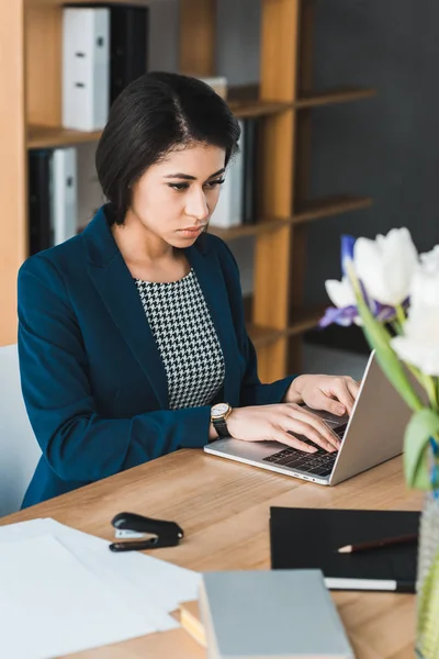 Attraktive Geschäftsfrau schaut auf Laptop-Bildschirm am Bürotisch — Stockfoto