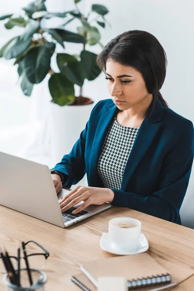 Junge Geschäftsfrau tippt im Büro auf Laptop an Tisch — Stockfoto